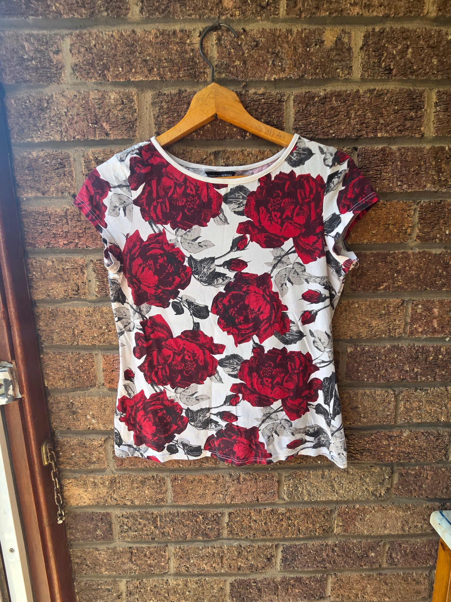 Close-up of Dorothy Perkins label showing size 10 UK 38 Euro inside neck of rose print top