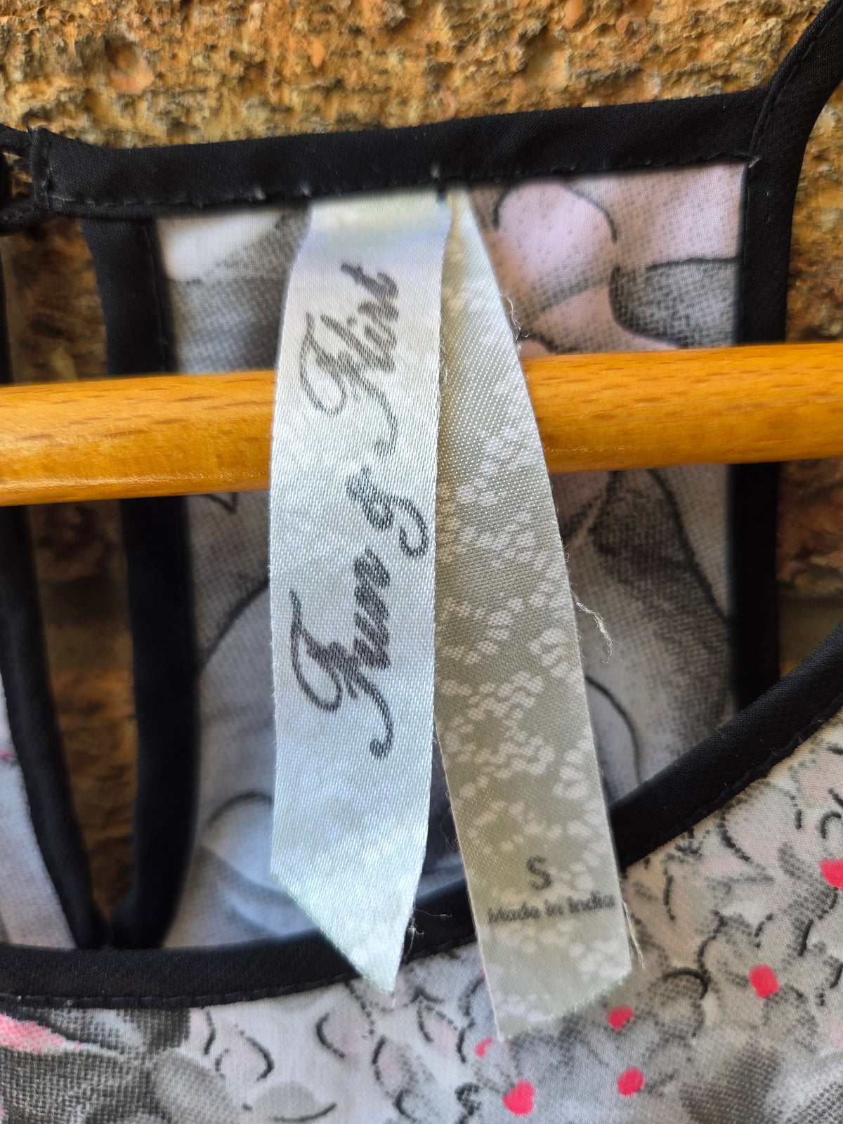 Close-up of Iron and Flint brand label inside neckline of grey floral cami top