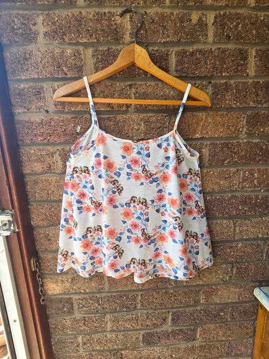 Dorothy Perkins cream butterfly floral cami top on wooden hanger against brick wall, back view showing scalloped hem